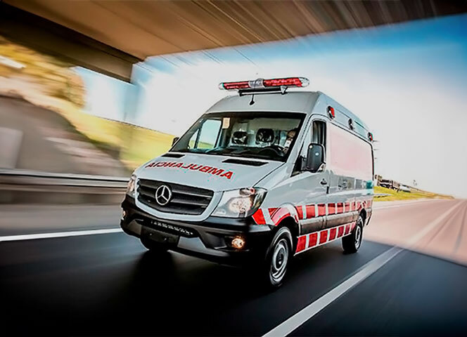 Uma ambulância branca e vermelha em movimento.